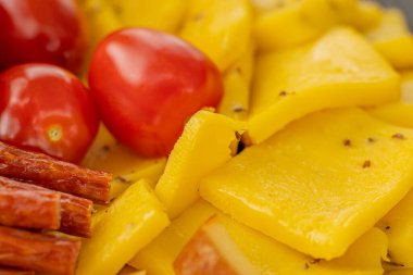 Peynirli atıştırmalıklar bir konteynırda. Farklı şekillerde dilimlenmiş peynir. Kutlama için peynir tahtası.