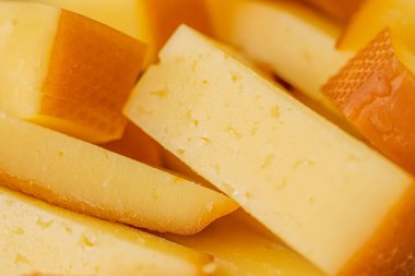 Peynirli atıştırmalıklar bir konteynırda. Farklı şekillerde dilimlenmiş peynir. Kutlama için peynir tahtası.