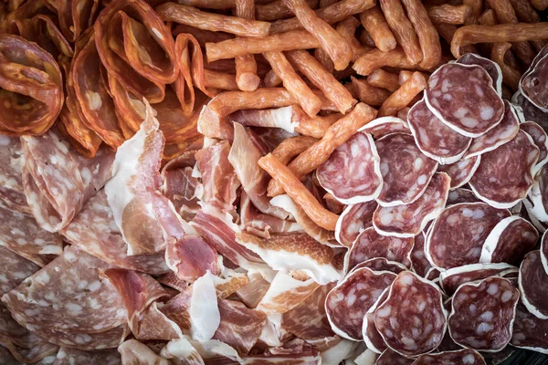 stock image Cured meat with toppings. Homemade salami, chorizo and other cured sausages. Dried sausages cut into thin slices