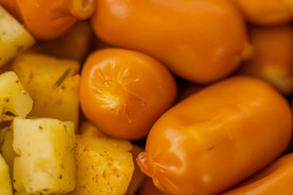 Peynirli atıştırmalıklar bir konteynırda. Farklı şekillerde dilimlenmiş peynir. Kutlama için peynir tahtası.