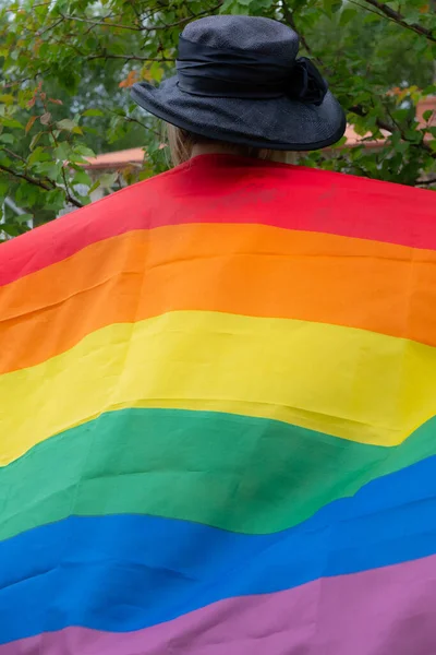 Yüzünde LGBT bayrağı olan bir kadın. Yanağında LGBT bayrağı olan ağlayan genç bir kadın. LGBT üyelerinin hakları ve eşitliğinin ihlali kavramı. Kısa saçlı genç bir kadın. 