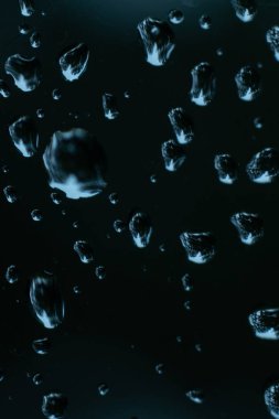 Cama su damlıyor. Araba camında yağmur damlaları var. Pencere camında gök gürültülü iklim yağmuru