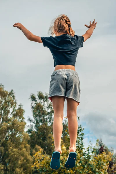 stock image A child jumps on a trampoline. The girl jumped in the air. A child with positive emotions jumps. Jumping on a trampoline can be a wonderful and enjoyable activity for children, promoting physical