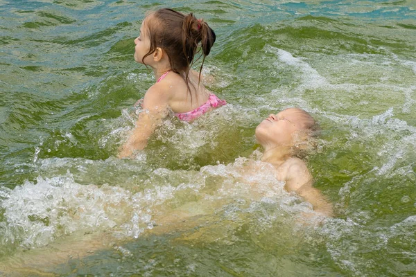 Çocuklar havuzda yalnız yüzerler. Havuz kenarındaki çocuklar. Su cesetlerinin yanında çocukların güvenliği