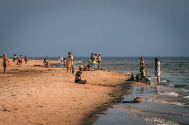 Deniz kenarında sıcak bir yaz. İnsanlar kumsalda güneşleniyorlardı..