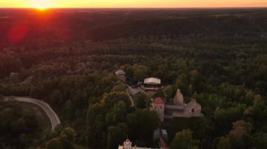Gün batımında Sigulda Kalesi. Saray sahnesinde opera günleri. Antik Sigulda Kalesi 'nin Parkı