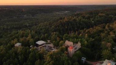 Gün batımında Sigulda Kalesi. Saray sahnesinde opera günleri. Antik Sigulda Kalesi 'nin Parkı