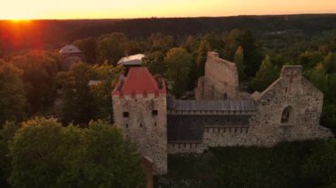 Gün batımında Sigulda Kalesi. Saray sahnesinde opera günleri. Antik Sigulda Kalesi 'nin Parkı