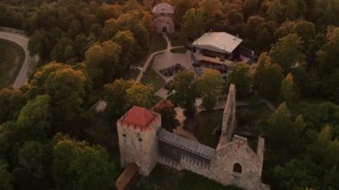 Gün batımında Sigulda Kalesi. Saray sahnesinde opera günleri. Antik Sigulda Kalesi 'nin Parkı