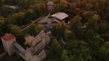 Gün batımında Sigulda Kalesi. Saray sahnesinde opera günleri. Antik Sigulda Kalesi 'nin Parkı