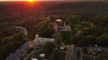 Gün batımında Sigulda Kalesi. Saray sahnesinde opera günleri. Antik Sigulda Kalesi 'nin Parkı