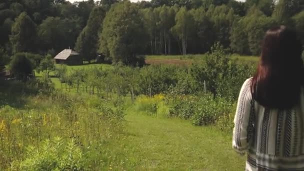 女性が家への田舎の道を歩いています — ストック動画