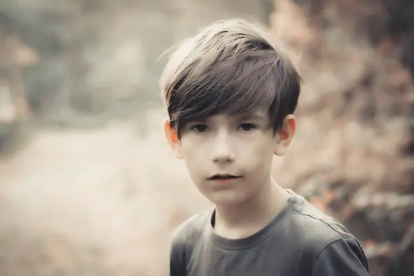 少年はカメラを見ている 子供は森で自然を楽しんでいる ソフトセレクティブフォーカス — ストック写真