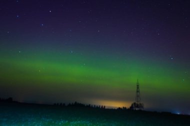 Letonya Gökyüzü Sonbaharda Yeşil Aurora. Gece vakti Aurora 'sının sakin manzarası, aydınlık yeşil manzara, yıldızlı göksel güzellik. Huzurlu Gece Gökyüzü, Yeşil Aurora Aydınlatıcı Gökyüzü