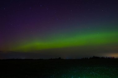 Letonya Gökyüzü Sonbaharda Yeşil Aurora. Gece vakti Aurora 'sının sakin manzarası, aydınlık yeşil manzara, yıldızlı göksel güzellik. Huzurlu Gece Gökyüzü, Yeşil Aurora Aydınlatıcı Gökyüzü