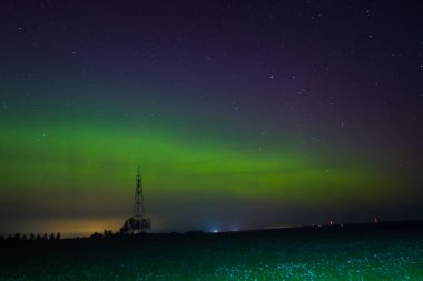 Letonya Gökyüzü Sonbaharda Yeşil Aurora. Gece vakti Aurora 'sının sakin manzarası, aydınlık yeşil manzara, yıldızlı göksel güzellik. Huzurlu Gece Gökyüzü, Yeşil Aurora Aydınlatıcı Gökyüzü