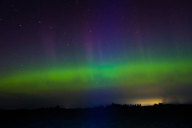 Letonya Gökyüzü Sonbaharda Yeşil Aurora. Gece vakti Aurora 'sının sakin manzarası, aydınlık yeşil manzara, yıldızlı göksel güzellik. Huzurlu Gece Gökyüzü, Yeşil Aurora Aydınlatıcı Gökyüzü