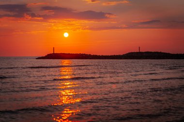 Deniz kenarında koyu kırmızı gün batımı. İskele arkaplanlı gün batımı. Yumuşak seçici odak