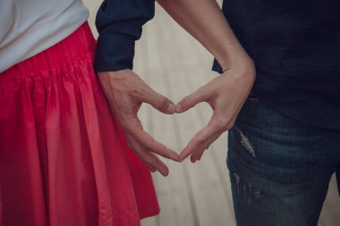 Kırmızı Giysili Mutlu Çift, Sevgi ve Bağlantı İfade Ediyor. Birbirine aşık bir çift el ele tutuşur, sevgi ve bağlılık gösterir..