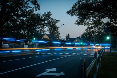 Şehir Trafiğinde Bulanık Hızlı Araba Hareketi Aydınlatılmış Işık İzleri. Hızlı bir şehir otobanındaki ışıklı arka lambaların bulanıklığı. Alacakaranlıktaki Şehir Sokağı Araba Işığı İzleri ve Yansımaları