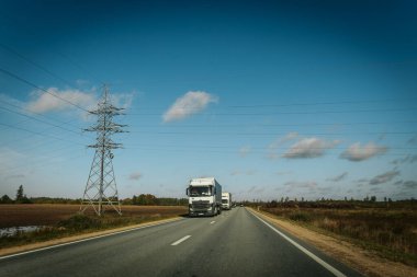 Riga - Valmiera yeni yolu asfaltladı. Letonya yollarında trafik. Asfalt kaplamalı yol. Ağır ve hafif araç hareketi