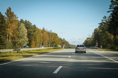 Riga - Valmiera yeni yolu asfaltladı. Letonya yollarında trafik. Asfalt kaplamalı yol. Ağır ve hafif araç hareketi