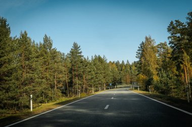 Riga - Valmiera yeni yolu asfaltladı. Letonya yollarında trafik. Asfalt kaplamalı yol. Ağır ve hafif araç hareketi