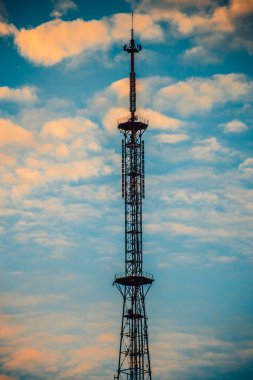 Sunny Sky 'ın altındaki yüksek katlı iletişim kulesi. Mavi gökyüzüne karşı yüksek teknoloji iletişim kulesi. İletişim kulesi ve hava manzaralı modern bir gökdelen..