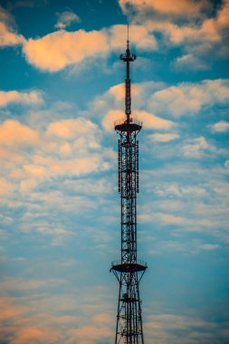 Sunny Sky 'ın altındaki yüksek katlı iletişim kulesi. Mavi gökyüzüne karşı yüksek teknoloji iletişim kulesi. İletişim kulesi ve hava manzaralı modern bir gökdelen..