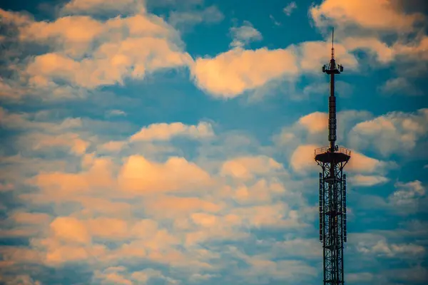 High-Rise Communications Tower Under Sunny Sky. High-tech communications tower against blue sky. A modern high-rise building with a communications tower and aerial view.