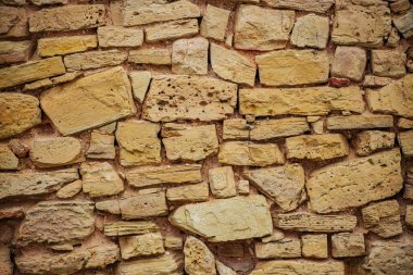 Tuğla ve Ahşap Detaylı Dokuma Taş Duvarı 'na yakın çekim. Ahşap ve tuğla işçiliği desenli desenli taş duvar.