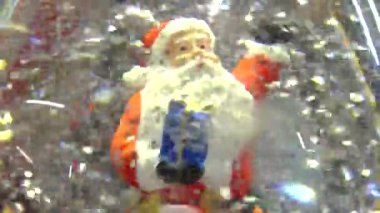 Noel Baba kardan adam kar taneleri ve yüzen simlerle dolu Noel cam kar küresi. Kar yağan Noel kar küresi