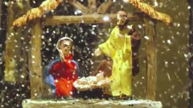 Noel Baba kardan adam kar taneleri ve yüzen simlerle dolu Noel cam kar küresi. Kar yağan Noel kar küresi. Noel ağacının yanında doğum sahnesi