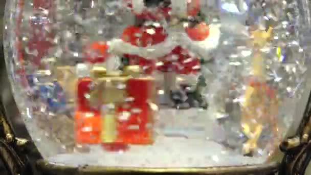 サンタクロースノーマン雪片とフローティンググリッターでクリスマスガラス雪の地球 雪が降るクリスマス雪の世界 クリスマスツリーによる出生シーン — ストック動画