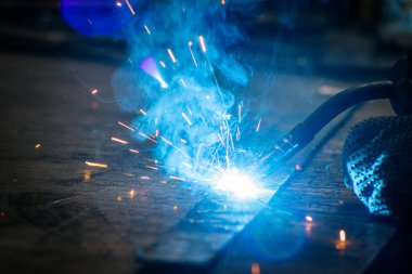 Usta atölyedeki işyerinde kaynak yapıyor. 