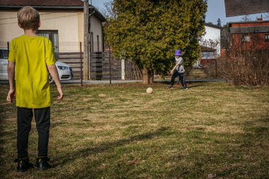 Baharda iki çocuk top oynar.