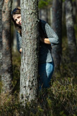 Bataklık yolunda yürüyen ve kameraya poz veren kadın.