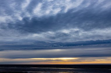 Gün batımında deniz ufkunda kara yağmur bulutları