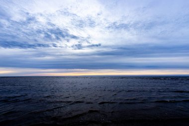 Gün batımında deniz ufkunda kara yağmur bulutları