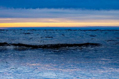 Deniz kıyısında soğuk baharda gün batımı