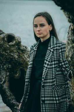 Linden sokağında, koyu renkli kareli ceketli, uzun saçlı, bulanık, doğal bir geçmişi olan bir kadın.