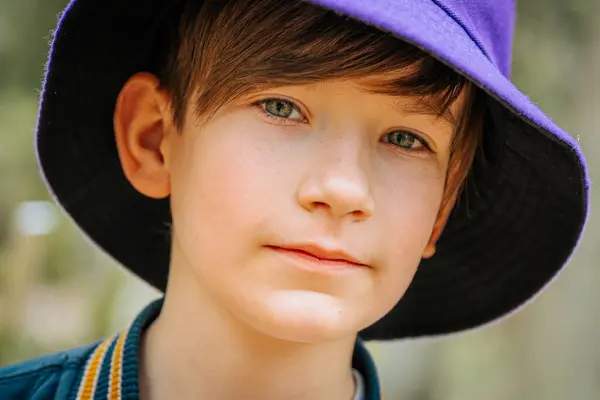 Şapkalı genç bir çocuğun portresi. Yakın plan. Ormanda şapkalı gülümseyen bir çocuğun portresi..