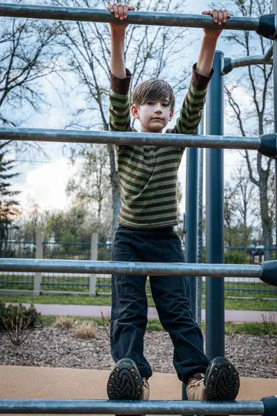 stock image child rested in the childrens playground. The boy was hanging on the bars. Smiling happy child