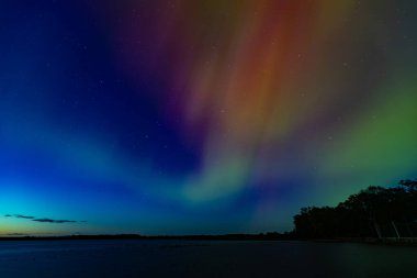 Burtnieks Gölü üzerinde Kuzey Işıkları. Aurora Borealis veya Kuzey Işıkları Letonya. Geceleri suda Aurora yansıması