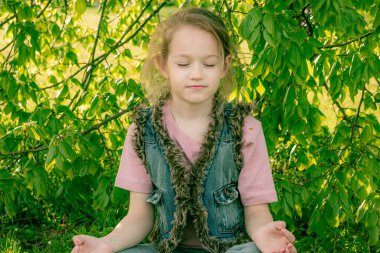 Kız gölgede oturup dinleniyor ve meditasyon yapıyor.