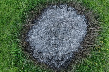 Küllerin yakın plan görüntüsü, ateşin kalıntıları, karmaşık dokular ve tonlarla, dönüşüm ve yenilenmeyi temsil ediyor..