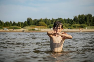 Güneşli bir günde okyanusta oynamanın heyecanını yakalayan, kolları havada suya neşeyle sıçrayan bir çocuk. Sahne, çocukluk ve yaz eğlencesinin tasasız ruhunu simgeliyor.