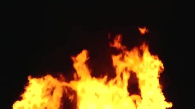 Şiddetli bir ateşin dramatik bir görüntüsü karanlık gece gökyüzüne karşı yoğun bir şekilde yanıyor. Parlak turuncu ve sarı alevler alevlerin ham enerjisini ve yıkıcı gücünü vurgular..