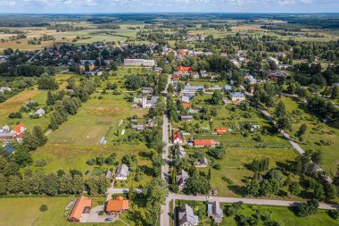 Letonya 'nın küçük Aloja kasabasının hava manzarasında konut evleri, kamu binaları ve yeşil alanlar yer alıyor. Kasaba bereketli kırsal ve tarımsal alanlarla çevrilidir.,