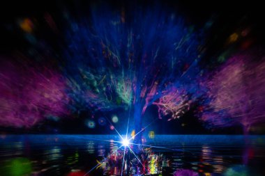 Ağaçların canlı renklerde büyüleyici bir ışık yansıması, sudaki yansımaları ve tabanındaki parlak yıldız patlaması ile karanlık bir sahneyi aydınlatır. Ekran canlı enerji yayıyor ve gerçek üstü bir sevgili.